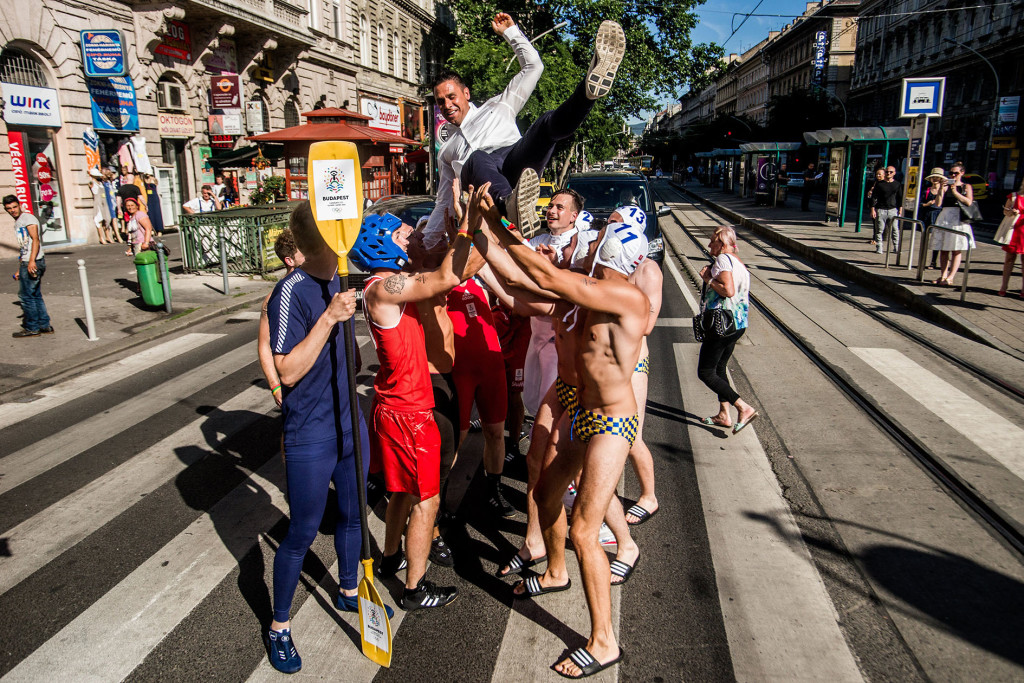 A Budapest 2024 sportolói flashmob csapatának tagjai magasba dobálják Kammerer Zoltánt (MTI Fotó: Balogh Zoltán)