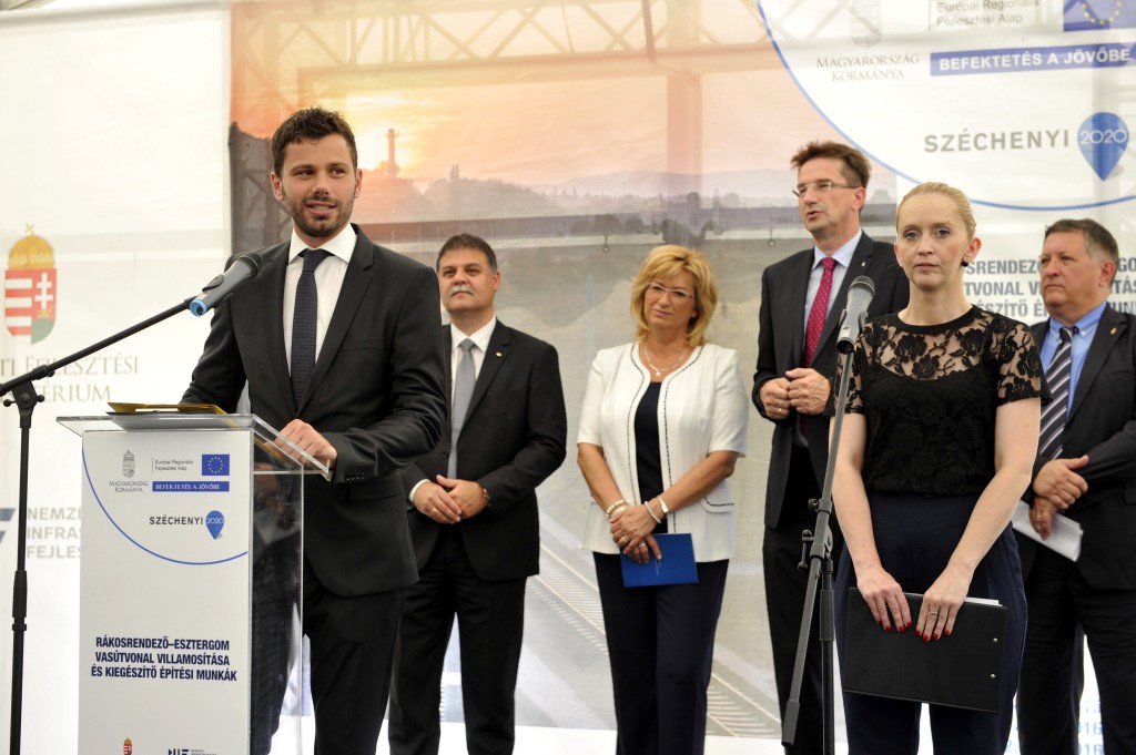 Loppert Dániel, a Nemzeti Infrastruktúra Fejlesztõ (NIF) Zrt. kommunikációs igazgatója beszédet mond a Rákosrendezõ-Esztergom vasútvonal villamosításának megkezdése alkalmából tartott ünnepségen az az esztergomi vasútállomáson 2016. július 27-én. A háttérben Völner Pál, a térség fideszes országgyûlési képviselõje, Komárom-Esztergom megye fejlesztési biztosa (j3), Mosóczi László, a Nemzeti Fejlesztési Minisztérium közlekedésért felelõs helyettes államtitkára (j), balról Tokaji Róbert, a MÁV Zrt. mûszaki igazgatója (b), Romanek Etelka (Fidesz-KDNP), Esztergom polgármestere. (MTI Fotó: Kovács Attila)